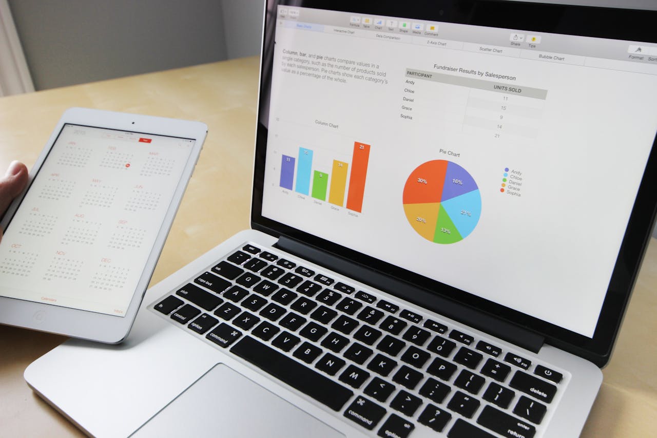 heros-img Laptop displaying charts and graphs with tablet calendar for data analysis and planning.